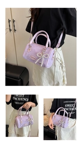 Macro detail of lavender crocodile pattern leather bag with pearl bow and heart charm