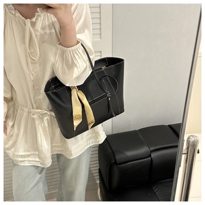 Mirror selfie showing the large black leather tote bag with white stitching and silk scarf