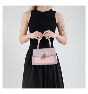 Detail of pink glitter handle and crocodile texture leather on stylish evening handbag