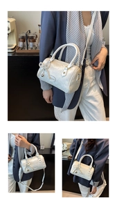Detail view of white textured Boston bag with pearl bow charm and detachable strap