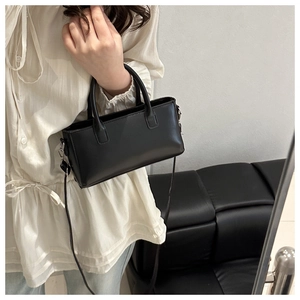 Detail of classic black mini square bag with adjustable shoulder strap and silver hardware