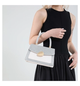 Detailansicht der weißen Tasche mit Kroko-Prägung, glitzernder Klappe und Goldschnalle