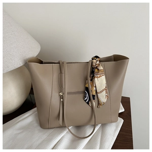 Detail of khaki tote bag with front zipper pocket and silk scarf on smooth leather