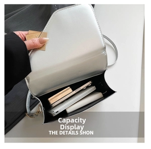 Interior detail of silver crossbody bag showing capacity for phone and cosmetics