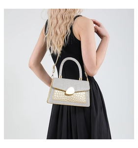 Detail of silver glitter and gold crocodile texture handbag with metal chain strap