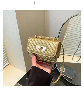 Close-up of gold mini crossbody bag with V-quilted pattern and elegant metal chain strap