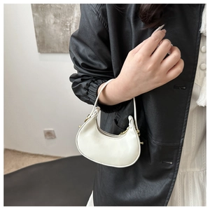 Dettaglio di una mini borsa a mezzaluna bianca in ecopelle lucida con cerniera in metallo oro