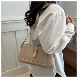 Détail du sac à bandoulière en cuir beige avec une boucle métallique rectangulaire élégante
