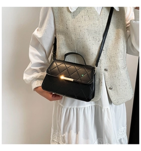 Détail du sac matelassé noir classique avec fermoir doré et bandoulière en chaîne