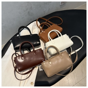 High-angle view of mini Boston-style bags in five colors with fashion embossing