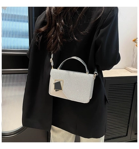 Detail of silver glitter crossbody bag with square buckle shown in a lifestyle setting
