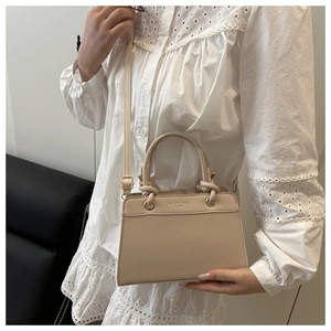 Detail of apricot matte leather tote featuring a rolled handle and fashion trend embossing