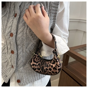 Gros plan du mini sac à main en croissant avec imprimé léopard et fermoirs dorés