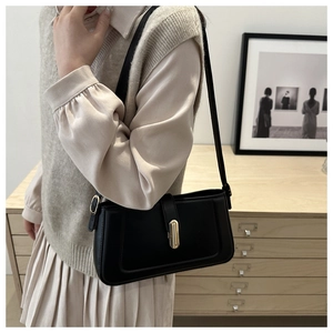 Gros plan d'un sac à bandoulière en cuir noir avec boucle métallique dorée élégante