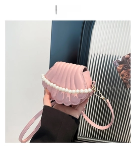 Pink shell shaped crossbody bag with pearl strap and textured pleated surface