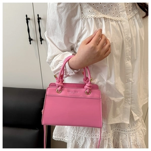 Detailed shot of pink tote bag with knotted handles and Fashion Trend brand engraving