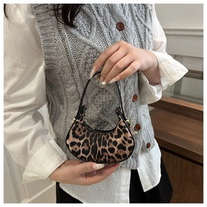 Dettaglio della mini borsa a mezzaluna con stampa leopardata e sottile manico nero chic