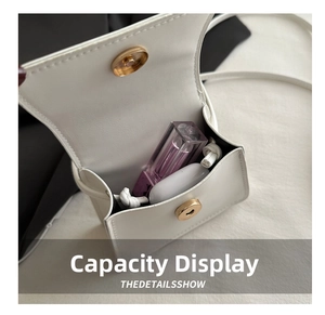 Internal storage detail of white mini crossbody bag showing lipstick and wireless earphones