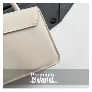 Close-up of cream leather crossbody bag featuring fine stitching and premium texture