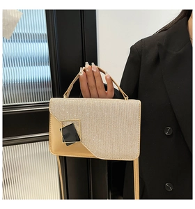 Detail of champagne gold sequin handbag featuring a stylish geometric clasp and top handle