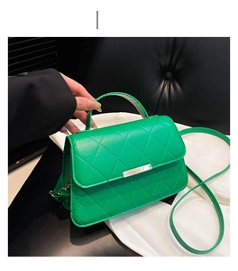 Détail d'un sac bandoulière vert matelassé avec couture losange et boucle en métal