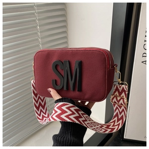 Détail du sac bandoulière en daim bordeaux avec ferrures dorées et sangle large