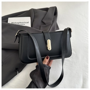 Détail du sac à bandoulière en similicuir noir avec fermoir doré et surpiqûres chic