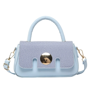 Light blue crossbody handbag with gold buckle and top handle on a clean white background