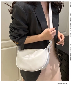 Detail of white crescent crossbody bag with smooth leather finish and zipper closure