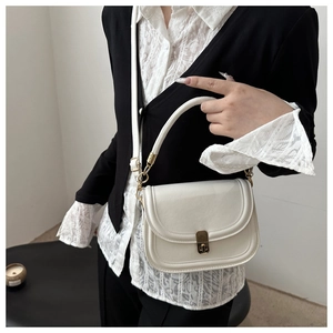 Detail of a white minimalist handbag featuring a vintage gold metal square buckle lock