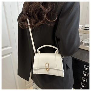 Détail du petit sac carré blanc en cuir avec boucle dorée en U et bandoulière