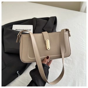 Détail d'un sac à bandoulière minimaliste en cuir beige avec un fermoir doré chic