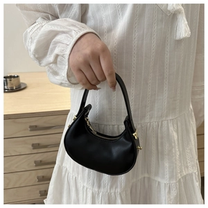 Dettaglio della mini borsa a mezzaluna nera opaca con cerniera dorata e fibbie