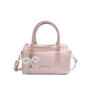 Pink Boston handbag with snake pattern texture, pearl bow charm, and gold hardware