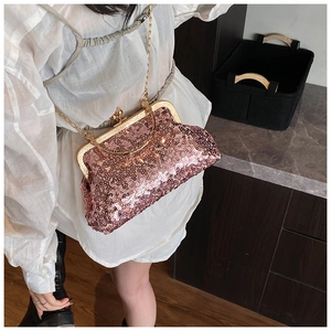 Detail view of pink sequin shell bag worn by model showing its shiny texture and chain strap