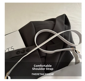 Detail of white PU leather shoulder strap with gold metal buckle on black suit jacket