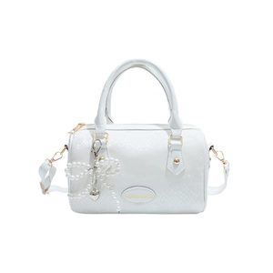 White Boston handbag with embossed texture and pearl bow charm on white background