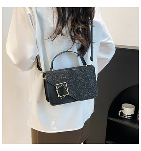 Close-up of black sequined crossbody bag with vintage golden square metal buckle