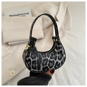 Dettaglio macro della borsa a mezzaluna leopardata con fibbia in metallo dorato e zip