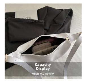 Spacious interior of white PU shoulder bag holding a wallet, phone, and notebook