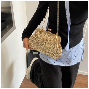 Detail view of a gold sequin evening bag with a kiss-lock closure and elegant chain strap