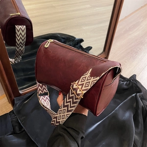 Burgunderrote zylindrische Umhängetasche mit Vintage-Lederstruktur und Jacquard-Gurt