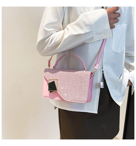 Close-up of pink glitter flap shoulder bag with gold square buckle on a female model