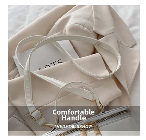 Detail of cream box bag showing lychee grain leather and gold zipper hardware