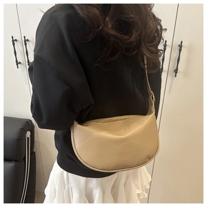Beige soft leather hobo bag worn by model, showing its size and half-moon shape