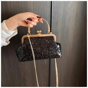 Close-up of black sequin evening bag with gold metal frame and round handle