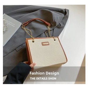 Détail du sac beige en toile avec bordure en cuir marron et bandoulière en chaîne dorée
