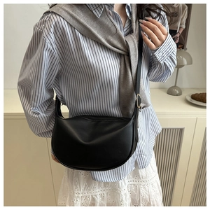 Detail view of black matte PU hobo bag with gold buckle on shoulder strap and zipper closure