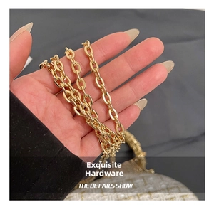 Close-up of elegant gold metal chain strap featuring high-gloss polished oval links