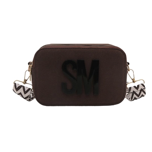 Sac caméra marron texturé avec logo SM et bandoulière à motifs sur fond blanc pur